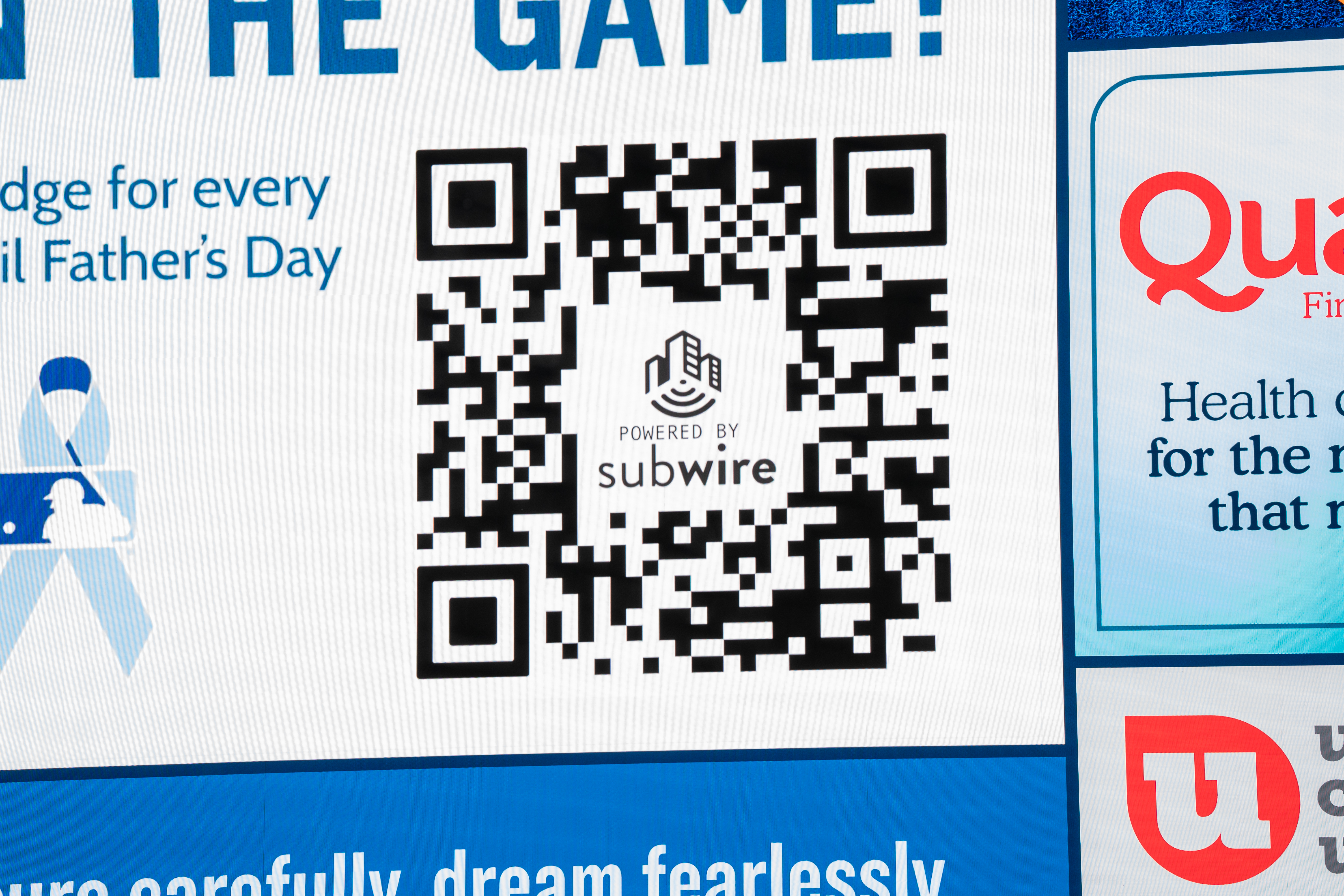 Fans engaging with mobile devices in stadium concourse